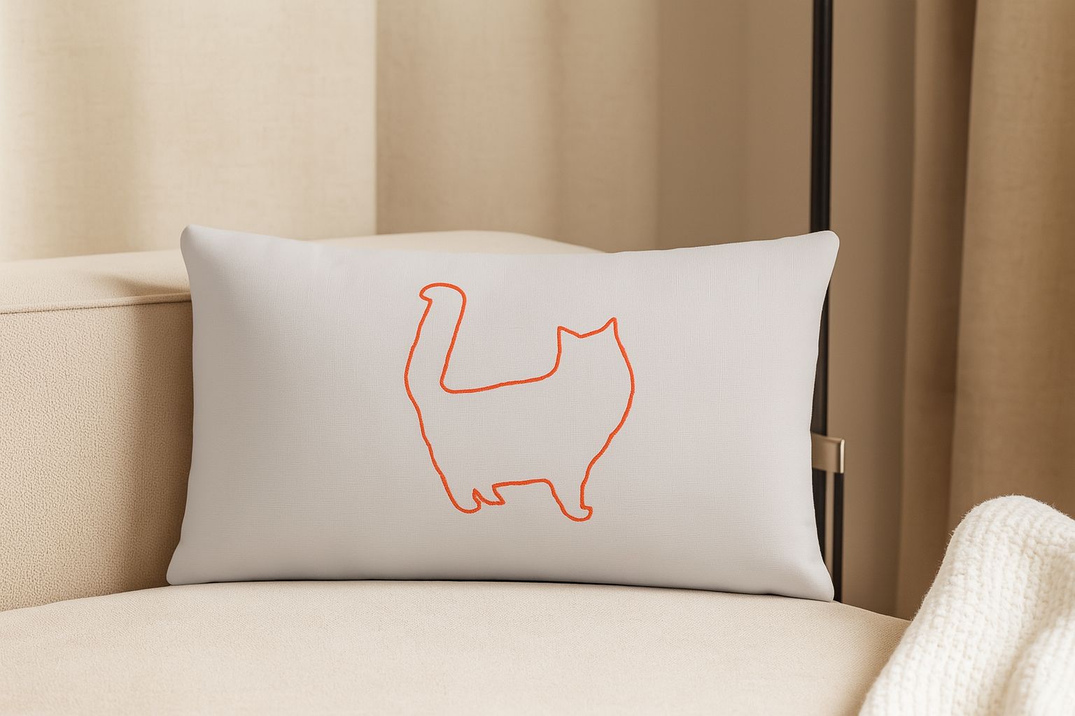 Cojín decorativo rectangular gris claro con silueta de gato en línea naranja.