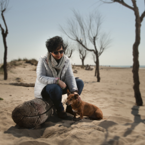 paola ceci fotografa, jugando con su perro entre los arboles , un paisaje abierto