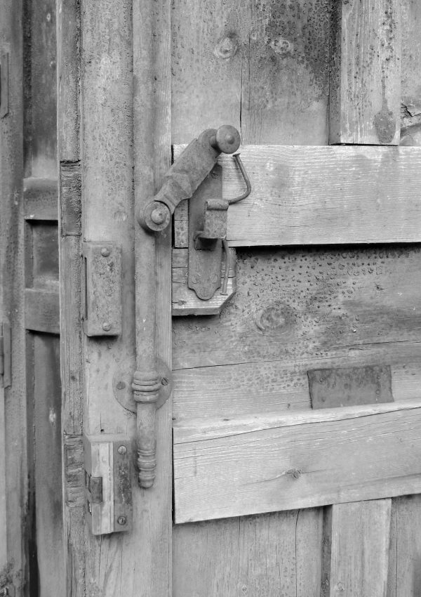 “Puerta antigua con textura desgastada en blanco y negro, fotografía artística y nostálgica”