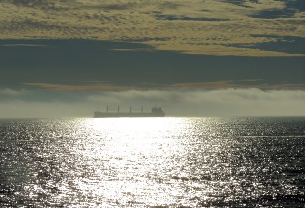 Horizonte cargado – Fotografía artística de barco sobre el mar
