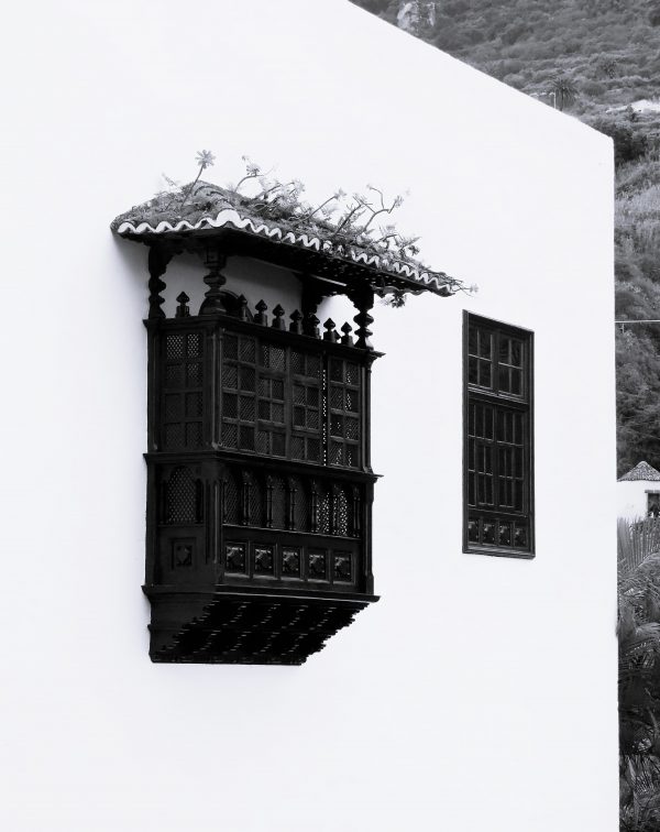 Ventana tradicional canaria en blanco y negro sobre fachada blanca, fotografía artística de arquitectura