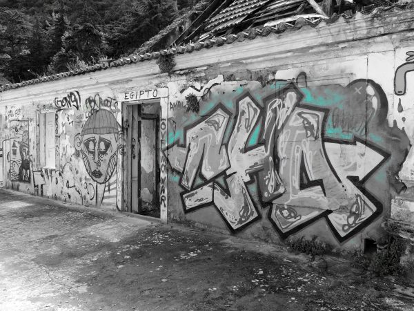 Fotografía artística de graffiti urbano en edificio abandonado de Lisboa